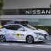 Image of a Nissan vehicle demonstrating autonomous driving capabilities on a busy public road, equipped with advanced sensors and technology.